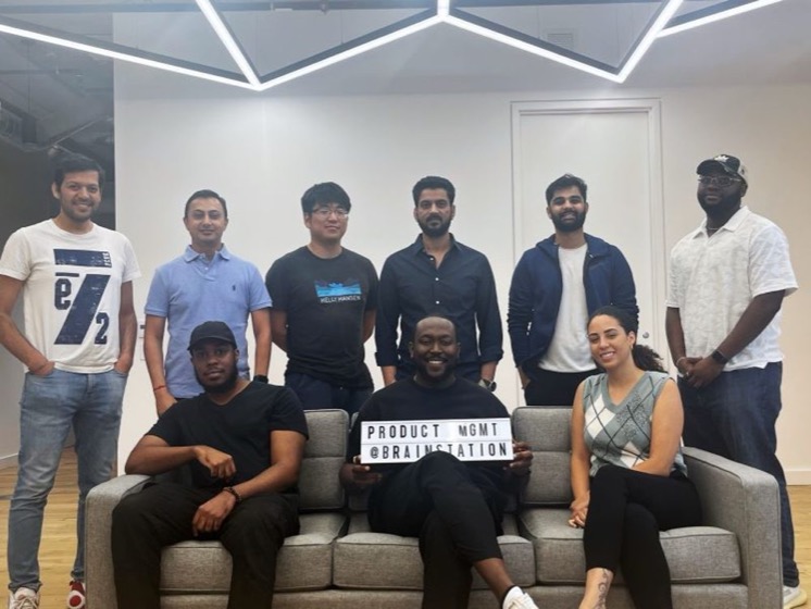Funto holding a Product Management @ BrainStation sign with his cohort